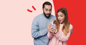 young couple looking at a cell phone with surprise and delight | Honor Credit Union
