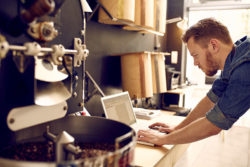 man on computer working in a workshop | Honor Credit Union