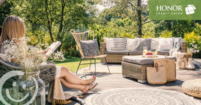 honor credit union has answers to your home equity questions; woman sitting on a chair on a patio reading a book in the sun