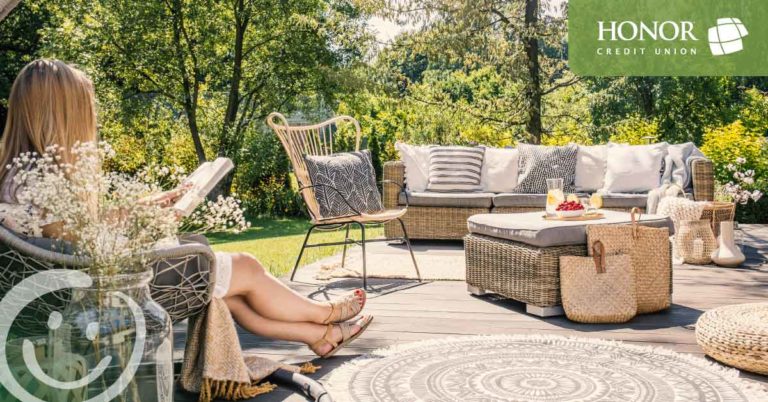 honor credit union has answers to your home equity questions; woman sitting on a chair on a patio reading a book in the sun