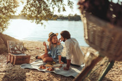 a young couple having a picnic on the beach | Honor Credit Union