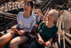 two girlfriends riding a wooden rollercoaster together | Honor Credit Union