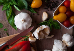 tomatoes garlic peppers and herbs for salsa on a wooden back ground | Honor Credit Union