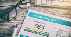 learn what credit is and why you need it; glasses and a pen sitting on a table next to a printed out credit report | Honor Credit Union