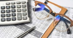 learn how the prime rate change might affect you; calculator, glasses, pen, and paperwork resting on a table | Honor Credit Union