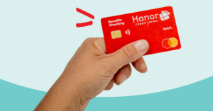 hand holding up red Benefits Checking debit card | Honor Credit Union