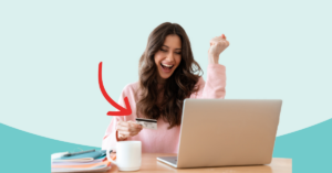 young women sitting at her laptop fist in the air while the other hand holds a credit card excitement on her face looking at her credit | Honor Credit Union
