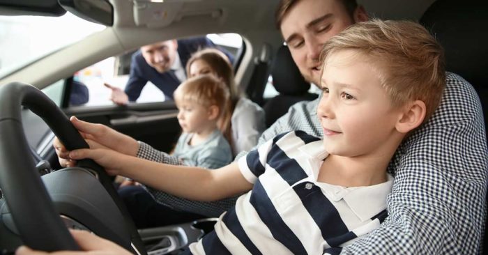 car truck down payment; father and son in driver's seat of new car