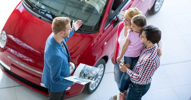 best time to buy a new car; photo of family shopping at a car dealership