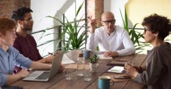 honor credit union has three tips to reduce business costs; photo of employees sitting at a table talking | Honor Credit Union