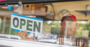 business owner changing sign to open | Honor Credit Union