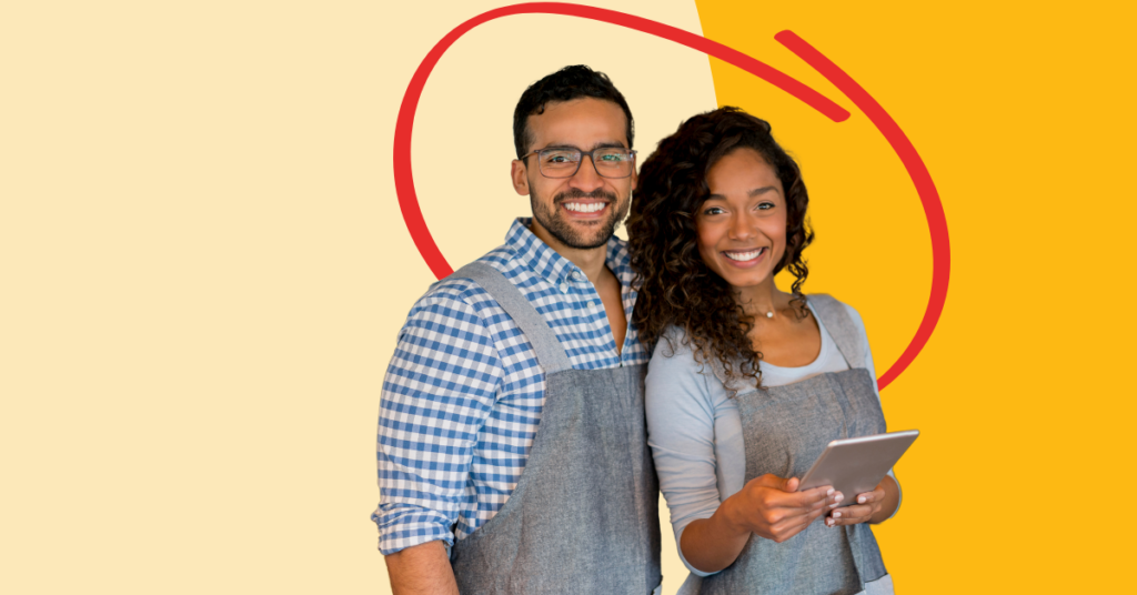 business owners in aprons smiling and holding a tablet