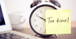 image of a sticky note on an alarm clock that reads tax time; honor credit union has tips to help make filing taxes easy | Honor Credit Union