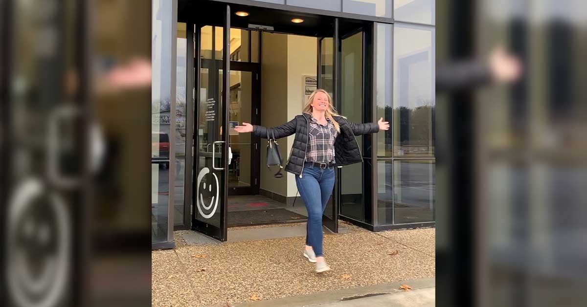 honor credit union can help you get out of credit card debt; photo of an honor member walking out of a member center smiling