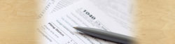 we can help you file taxes with instructions on how to find all of your honor financial documents; photo of a 1040 tax form with a pen resting on it | Honor Credit Union
