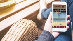 use your voice, fingerprint, facial recognition or a pin to log in to the honor app; photo of a hand holding a mobile phone with the honor app open | Honor Credit Union