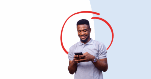young man looking at his cell phone smiling | Honor Credit Union
