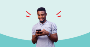 young man looking at his cell phone smiling | Honor Credit Union