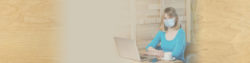 image of a woman wearing a mask while sitting at a desk with a laptop computer | Honor Credit Union