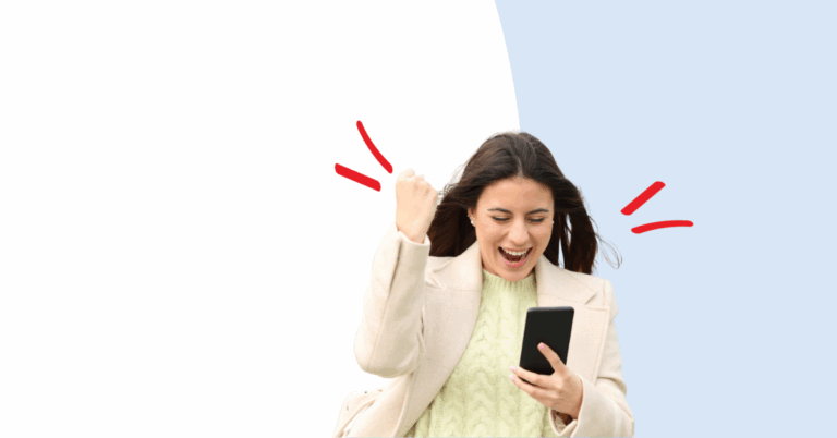 women looking at a cell phone with excitement and fist in the air
