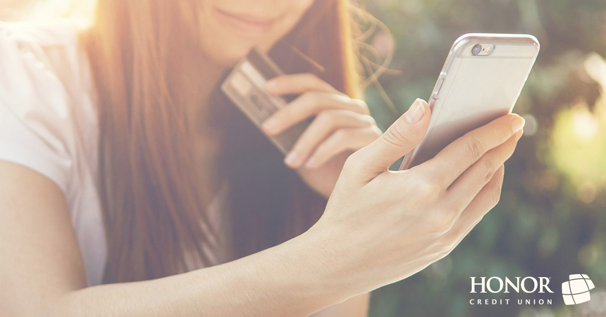 image of a woman holding a mobile phone in one hand and a credit card in another hand