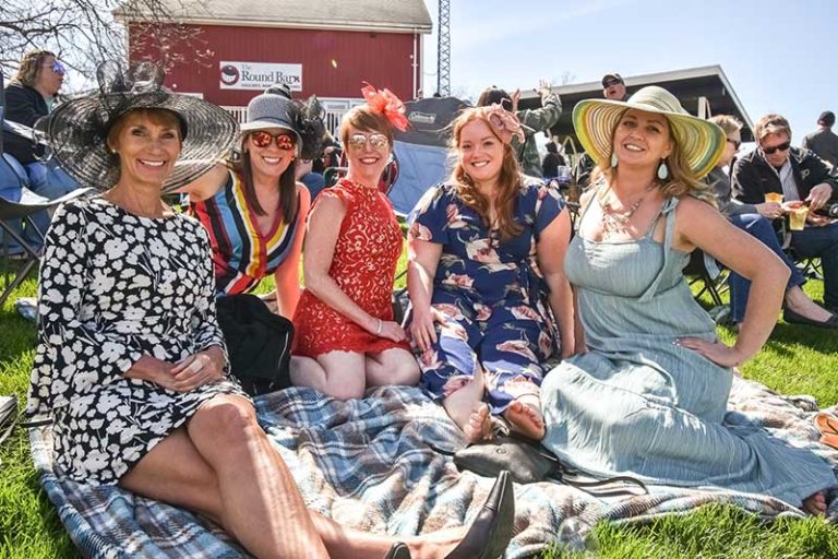 photo of women sitting at round barn winery and distillery on a sunny day