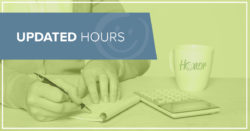 photo of a person writing a check at a table with a coffee mug and calculator also on the table | Honor Credit Union