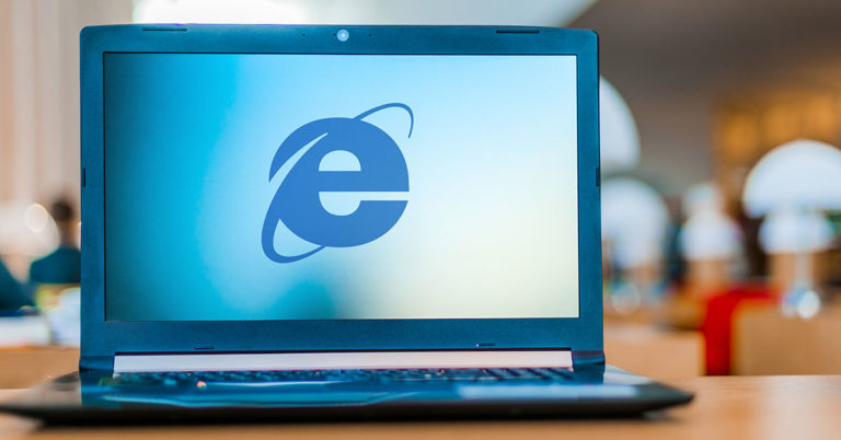 image of a laptop resting on a table with the internet explorer logo displaying on the laptop screen