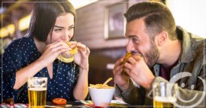 image of a man and woman sitting next to each other at a pub eating food | Honor Credit Union