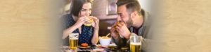 image of a man and woman sitting next to each other in a pub eating food | Honor Credit Union