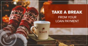 image of a coffee mug resting on a table with a person's feet in christmas socks also resting on the same table next to the mug | Honor Credit Union