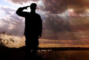 image of a soldier standing while saluting at dusk | Honor Credit Union