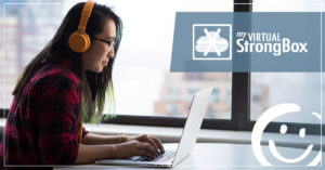 image of a woman wearing headphones while typing on a laptop keyboard | Honor Credit Union