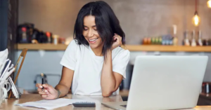 women checking finances with calculator and laptop | Honor Credit Union