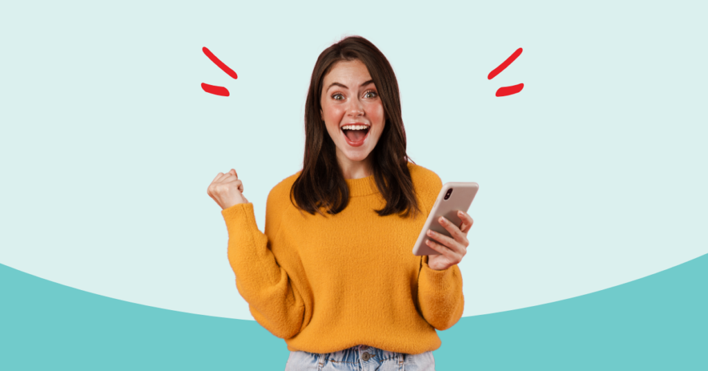 young women with a cell phone in one hand and the other making a fist with a huge smile on her face because she boosted her credit score