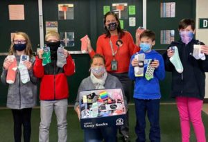 photo of students standing together for a photo of a sock donation presentation | Honor Credit Union