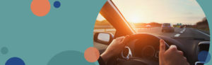 image featuring a blue sage solid background with orange and blue circles on the left side and a stock photo of hands on a steering wheel in a vehicle driving towards a sunset | Honor Credit Union