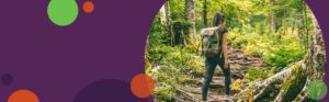 photo of a woman hiking in the woods overlaid on a purple background with green and orange circles on the image | Honor Credit Union