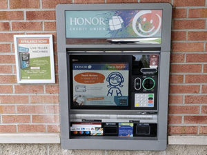 photo of an honor credit union atm live teller machine installed in the side of a member center building in a drive thru lane | Honor Credit Union