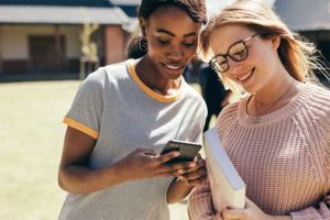 photo of two girls looking at a phone | Honor Credit Union