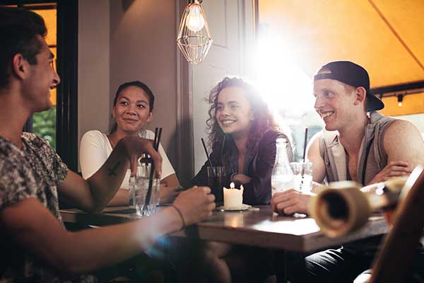 group of friends sitting at table talking