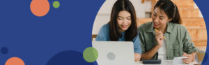 two women sitting at a table looking at paperwork and using a calculator | Honor Credit Union