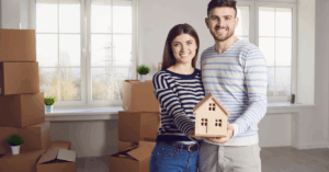 a young couple holding a small model of a house | Honor Credit Union