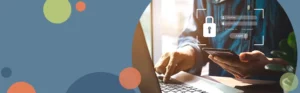 person looking at a mobile phone while typing on a laptop computer | Honor Credit Union
