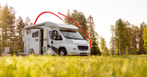 White motorhome parked on a sunlit grassy field with pine trees in the background | Honor Credit Union
