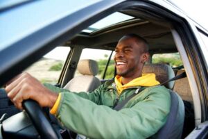 man driving a car while smiling | Honor Credit Union