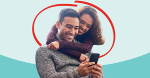 Young couple looking at a phone together happily | Honor Credit Union