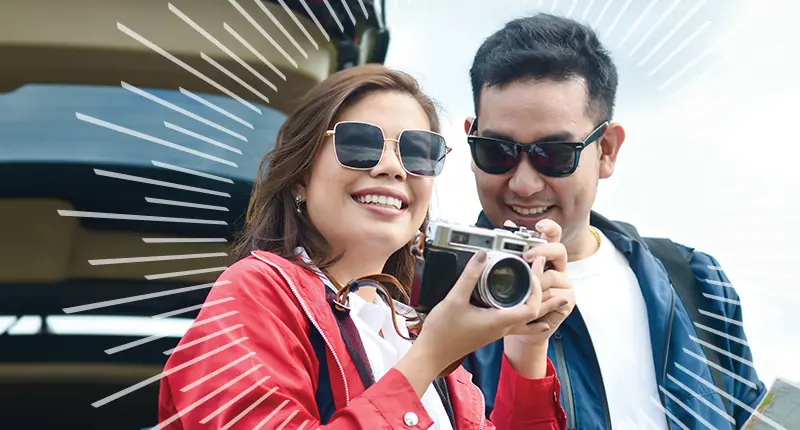 man and woman wearing sunglasses outside using a camera