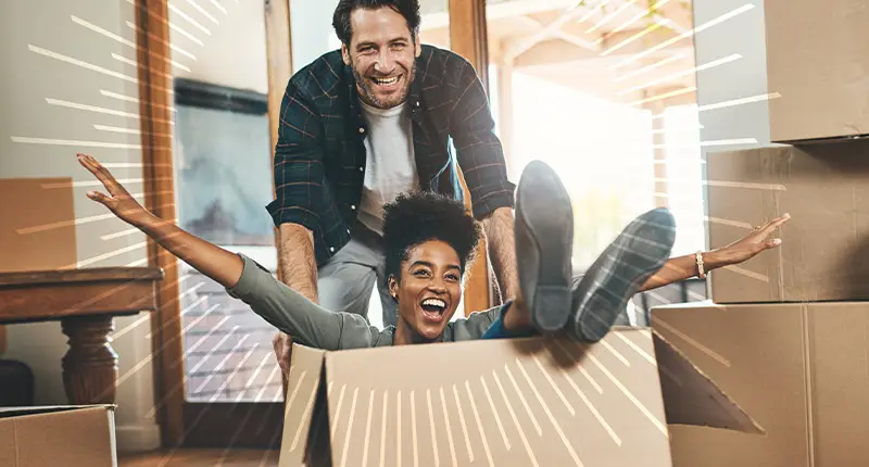 woman sitting in box being pushed by a man