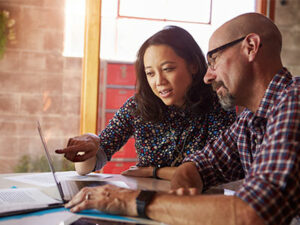 woman pointing at computer screen while man watches | Honor Credit Union